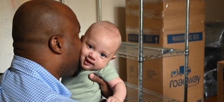 A man kissing a baby after deciding where to live in NYC.