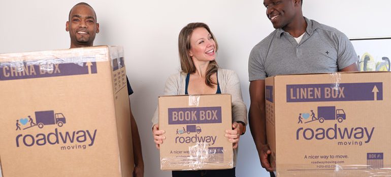 Happy people smiling and holding boxes