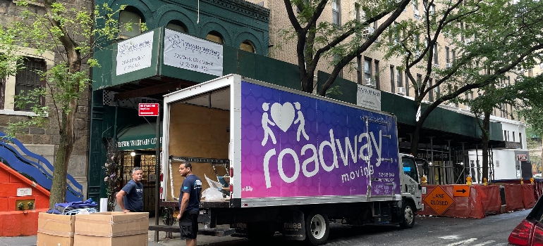 Roadway movers next to the moving truck ready to tell you about the places to move from NYC